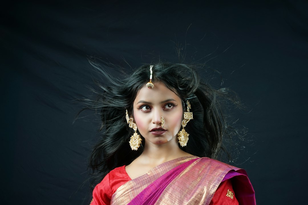 Woman in a red and white Bengali saree during Durga Puja
